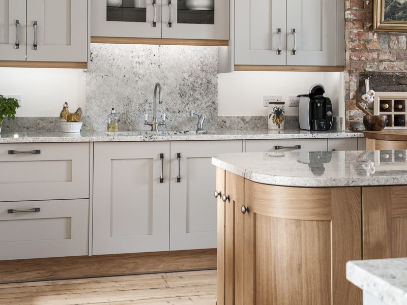 grey kitchen with wood floors and island