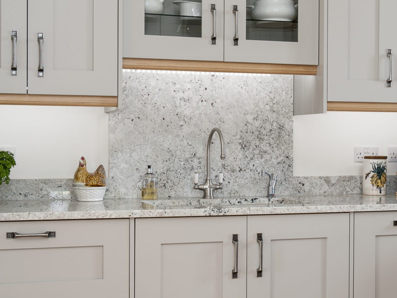 grey kitchen with swan neck tap and wood floor