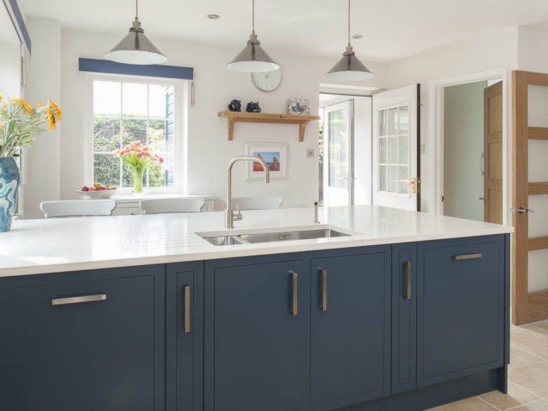 blue kitchen island with pendant lamps
