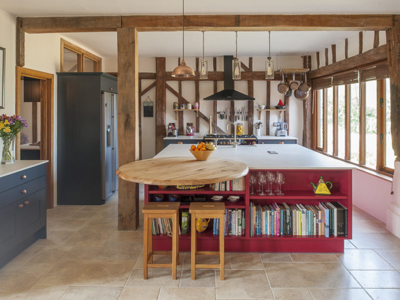 red kitchen island with beams and bar stools