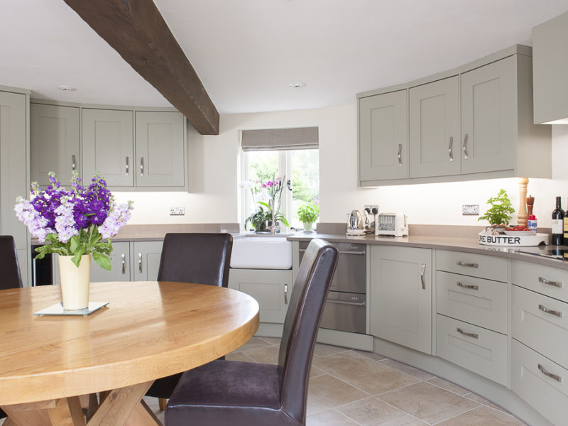 round grey kitchen with wood dining table