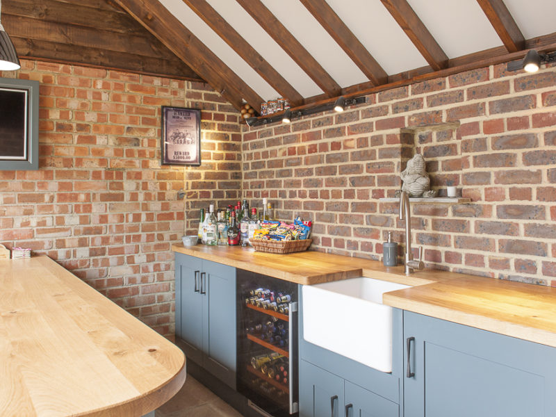 blue outside bar with wood worktops and brick wall